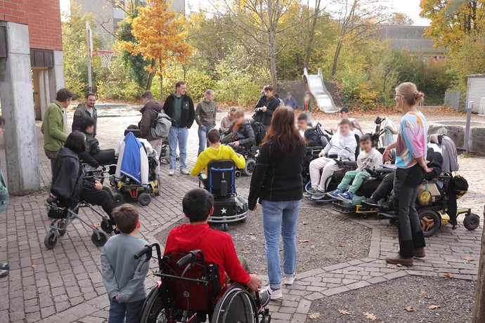 Besprechung auf dem Schulhof. Eine Gruppe steht im Kreis.