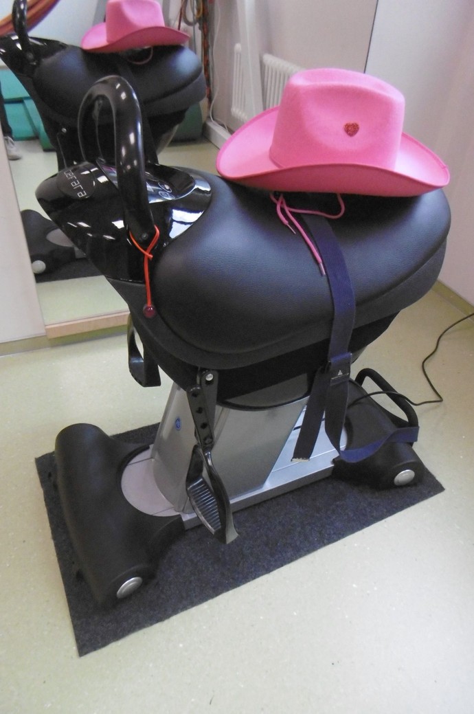 Ein Reitsimulator auf dem ein pinker Cowboyhuut liegt