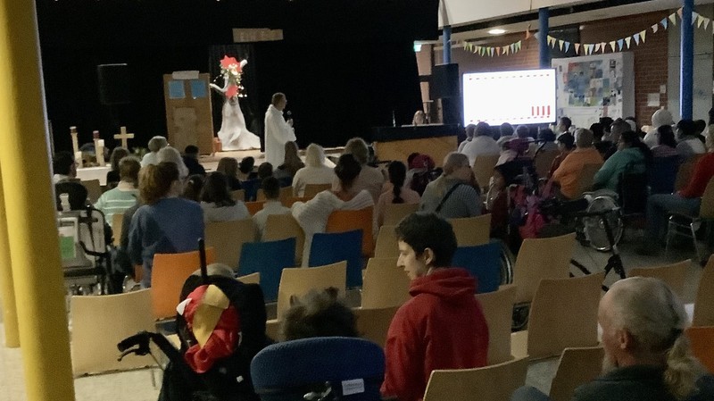 Blick ins gefüllte Forum. Ein Pastor redet ins Mikrophon.