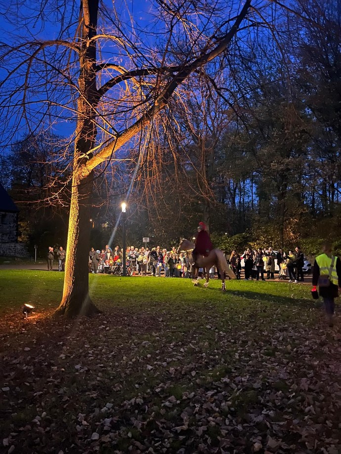 Die Primarstufe steht draußen: Das Martinspferd ist da und Laternen leuchten.