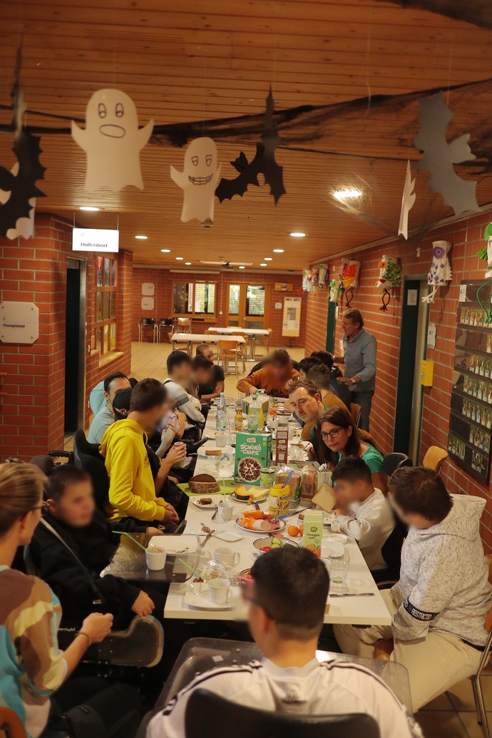 Racletteessen an einer langen Tafel.