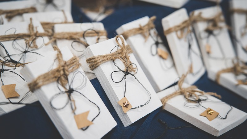 Engel aus Draht liegen aufgereiht auf einem Tisch.