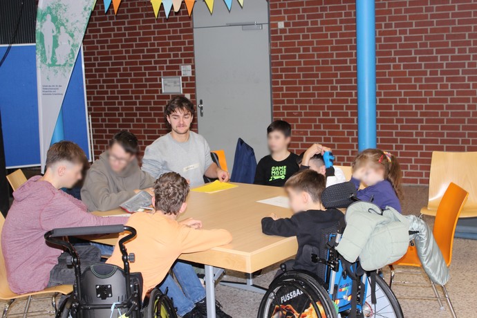 An einem Gruppentisch sitzen SchülerInnen und besprechen sich.