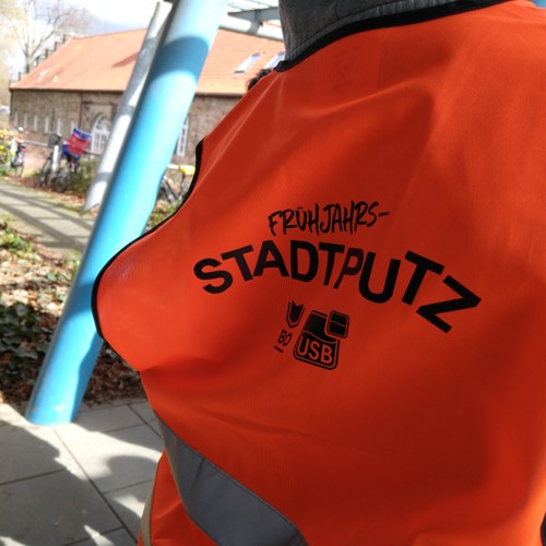 eine orangene Warnweste mit dem Aufdruck "Stadtputz"
