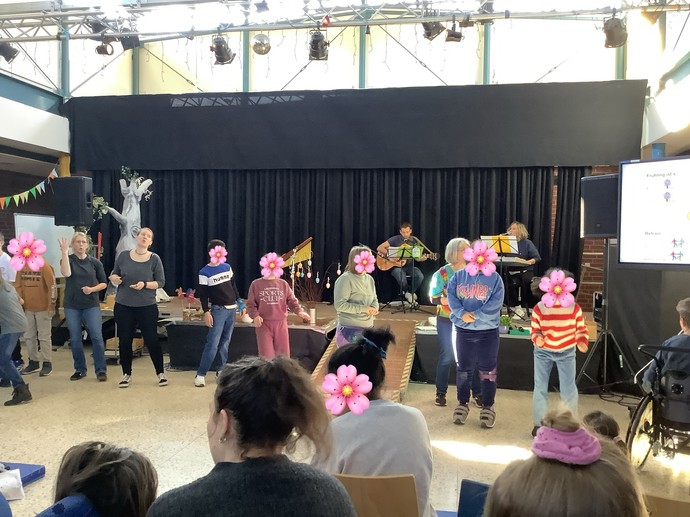 Eine Gruppe SchülerInnen steht vor der Bühne und singt zusammen