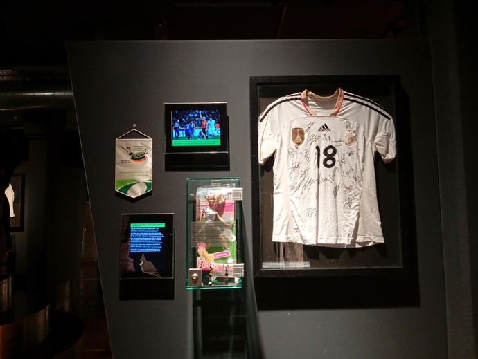 Ausgestelltes Trikot, Wimpel und ein Bildschirm im Sportmuseum