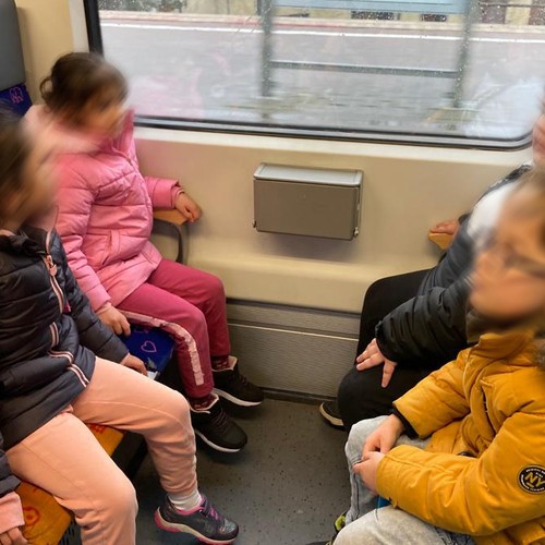 vier Kinder sitzen in einem Viererabteil einer S-Bahn und blicken aus dem Fenster