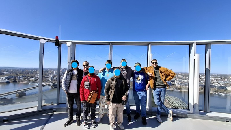 Eine Gruppe steht auf einem Aussichtsturm und lacht in die Kamera.