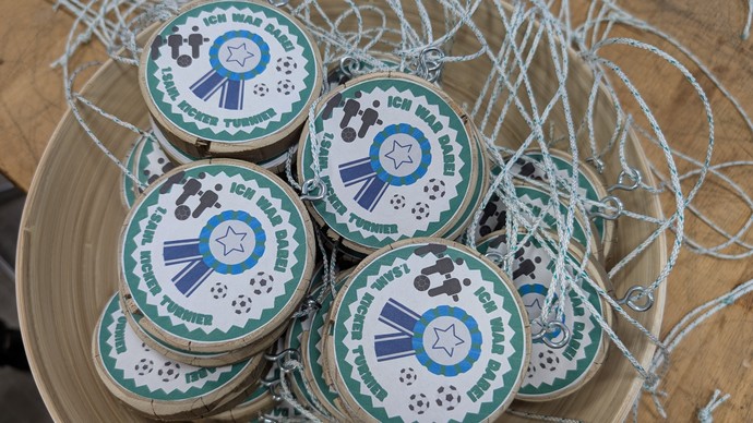 Medaillen aus Holz liegen in einer Schüssel.