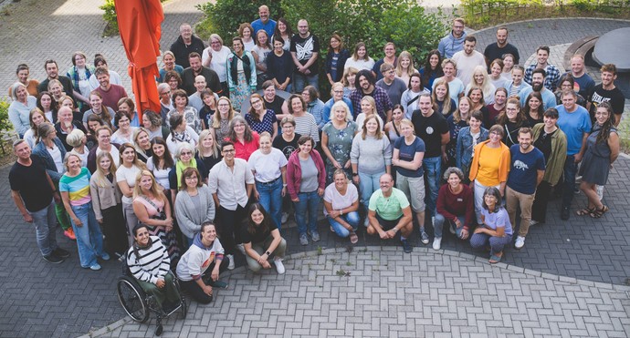 Gruppenbild des Kollegiums der Schule am Haus Langendreer von schräg oben fotografiert - alle schauen nach oben und lachen.