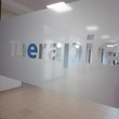 Schriftzug "Therapie" an der Glastür zum Therapie-Flur: das Glas ist matt, die Buchstaben sind durchsichtig.