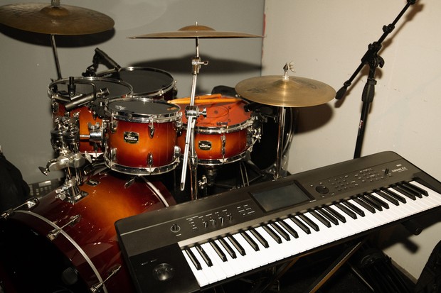 Ein Schlagzeug und ein Keyboard stehen in einer Ecke.