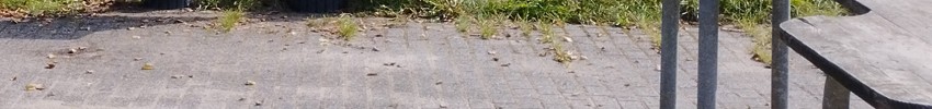 ein Schulhof, rechts ein Sandspieltisch, im Hintergrund eine Kommunitkationstafel mit 6 mal 11 Symbolfeldern