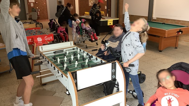 Einige SchülerInnen spielen Kicker und jubeln.