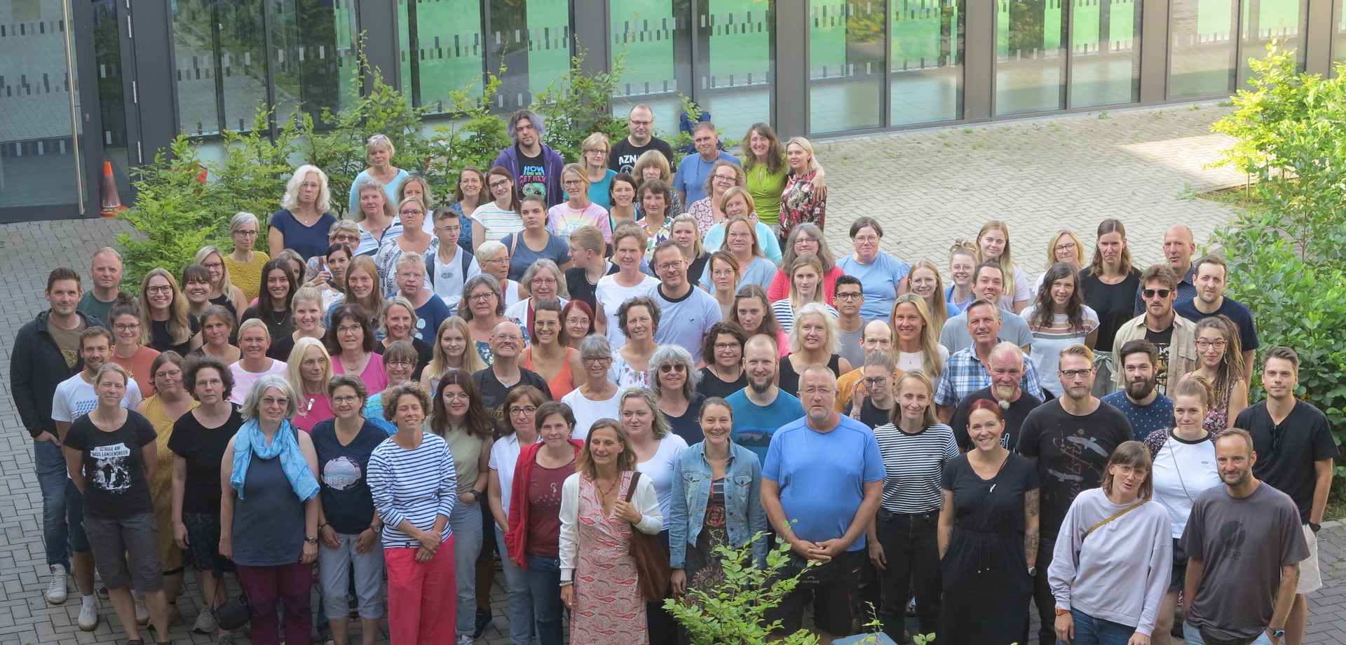 Gruppenfoto des gesamten Kollegiums aus der Vogelperspektive. Alle schauen nach oben.