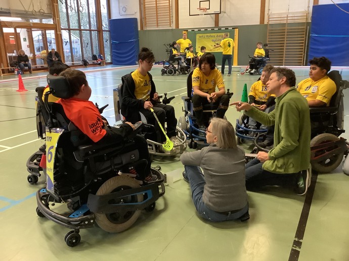 Eine E-Hockeymannschaft bespricht sich im Kreis