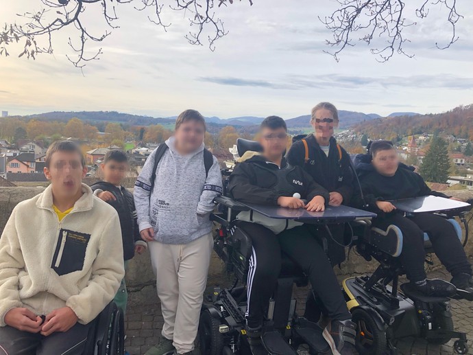 Gruppenbild von einem Aussichtspunkt mit Landschaft im Hintergrund.