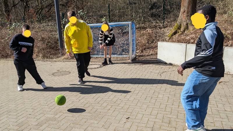 Vier Schüler/Schulerinnen spielen Fußball