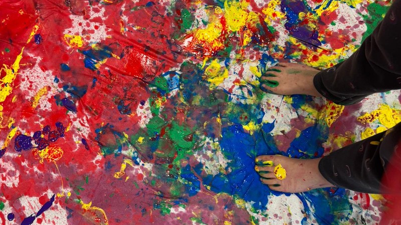 Ein buntes Tuch und Füße voller Farbe.