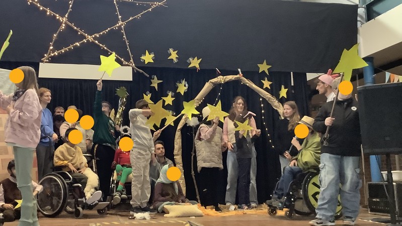 Viele Schülerinnen und Schüler sind auf der Bühne und halten Sterne in der Hand