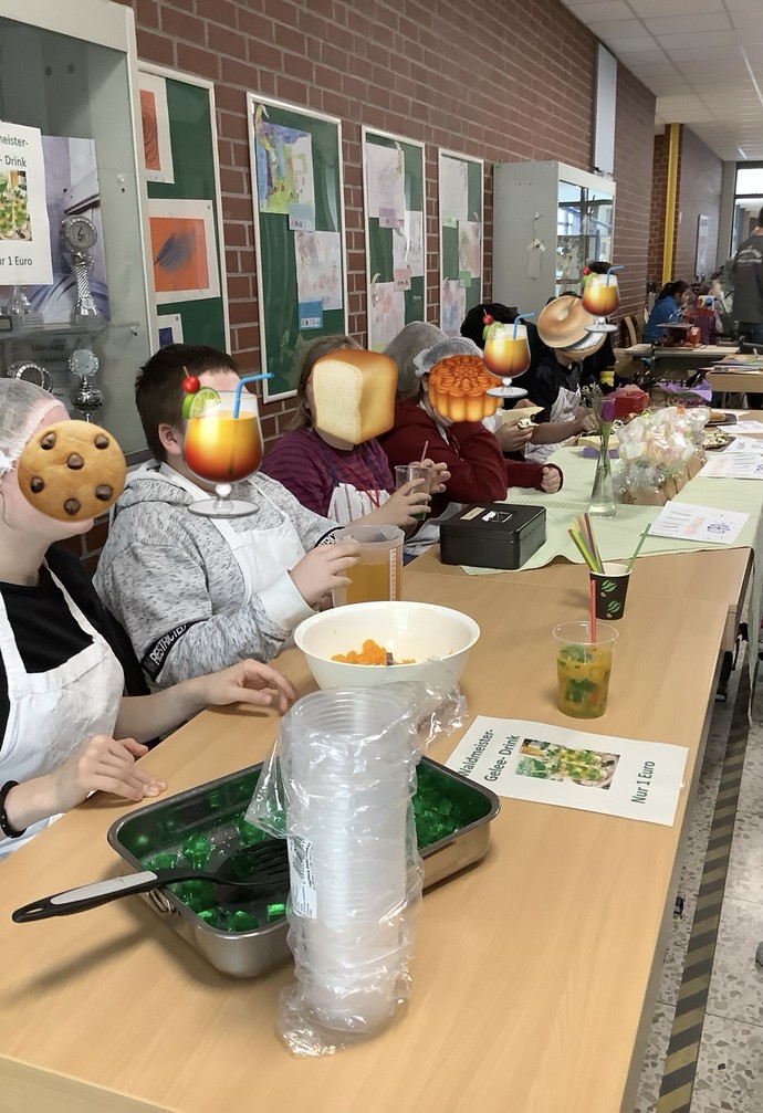 SchülerInnen sitzen hinter Tischen und verkaufen Snacks.