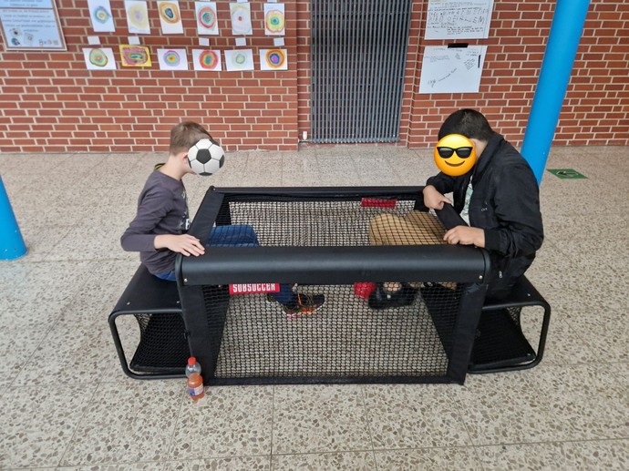 Zwei Schüler spielen Sitzfußball