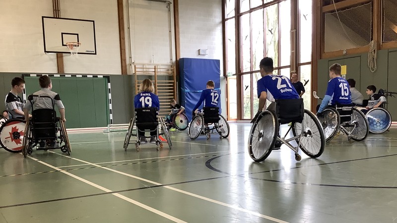 Einige Aktivrollstuhl-Hockeyspielerinnen und Spieler im Spielgeschehen.