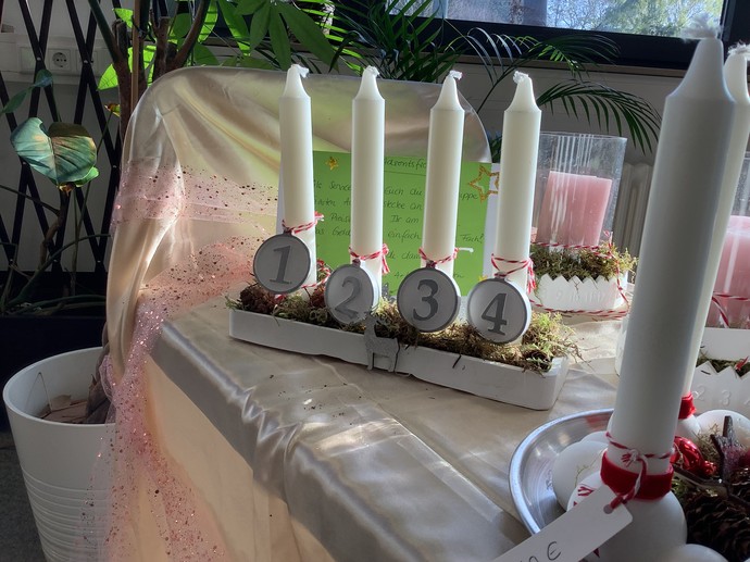 Ein Weihnachtsgesteck mit 4 weißen Kerzen.