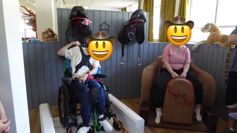 Zwei SchülerInnen sitzen auf Reitsimulatoren