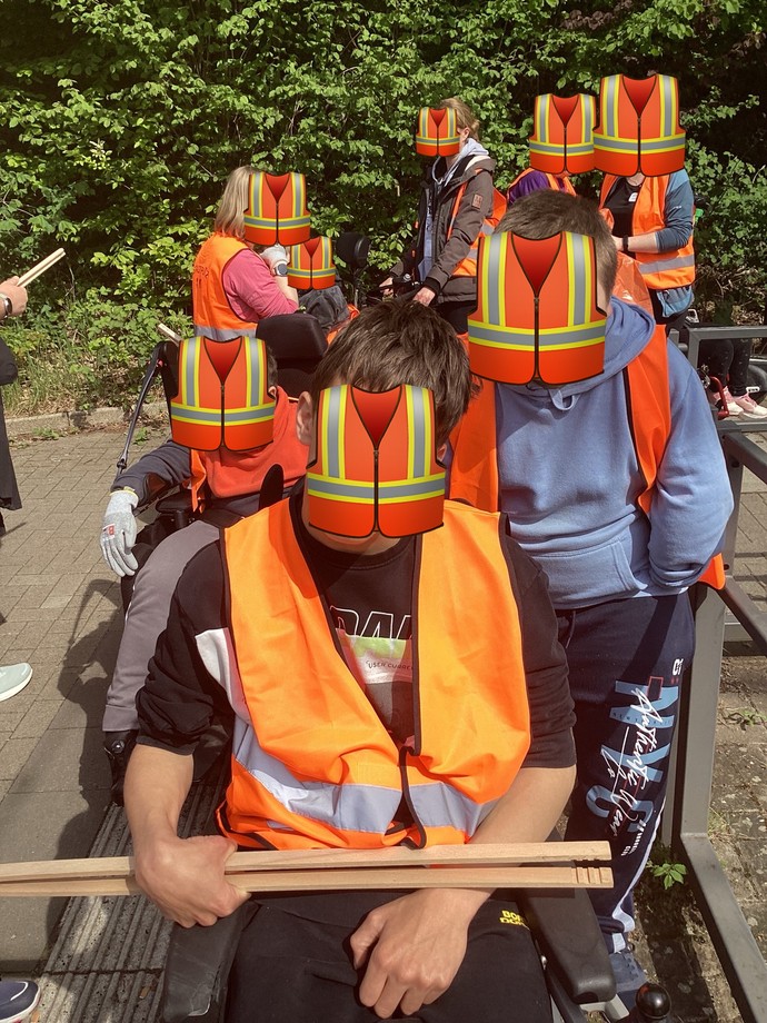 Eine Gruppe SchülerInnen, ausgestattet mit Westen und Zangen.