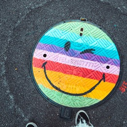 EIn regenbogenbunter Smiley der zwinkert