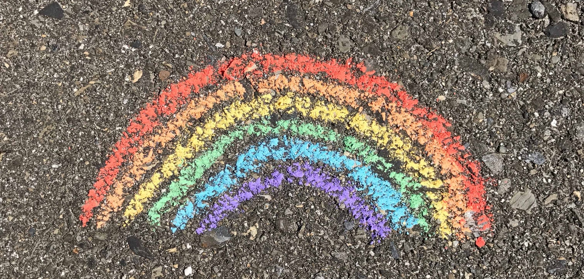 ein Regenbogen mit Kreide auf Asphalt gemalt