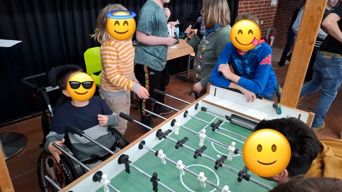 Spielszene aus einem Kickerspiel. Vier Personen spielen.