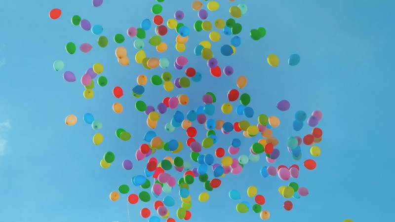 Viele Bunte Luftballons vor blauem Himmel.